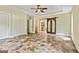 Spacious main bedroom with tile floors, a ceiling fan, a large walk-in closet, and an arched entry to the bathroom at 324 Chimney Sweep Cir, Peachtree City, GA 30269