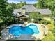 Aerial view of a backyard featuring a large in-ground pool, fire pit and covered outdoor living space at 324 Chimney Sweep Cir, Peachtree City, GA 30269