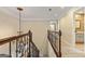 View of staircase with wrought iron railing, and the hallway leading to bathroom with granite countertop and mosaic backsplash at 324 Chimney Sweep Cir, Peachtree City, GA 30269