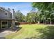 Large backyard with a covered patio, mature trees, and a wood fence, creating a private outdoor space at 120 Bowfin Bay, Peachtree City, GA 30269