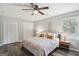 Comfortable bedroom featuring wood floors, ceiling fan, and ample closet space for organized living at 120 Bowfin Bay, Peachtree City, GA 30269