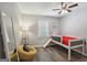 Bedroom with a wooden floor, featuring a twin bed with red blanket, full-length mirror and a cozy chair at 120 Bowfin Bay, Peachtree City, GA 30269