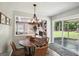 Dining area featuring a unique wood table, chandelier lighting, and a view into the living room and backyard at 120 Bowfin Bay, Peachtree City, GA 30269