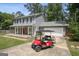 Gray two-story home with a red golf cart parked in the driveway in front of the garage at 120 Bowfin Bay, Peachtree City, GA 30269