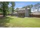 Exterior view of a home with a well-maintained backyard and covered patio, surrounded by mature trees at 120 Bowfin Bay, Peachtree City, GA 30269