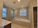 Bright bathroom featuring a shower and soaking tub with neutral tile at 1946 Jeffery Nw Rd, Atlanta, GA 30318