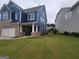 A well-maintained yard with stone and blue siding, two-car garage, and a glimpse of the home's backyard at 1946 Jeffery Nw Rd, Atlanta, GA 30318