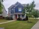 Charming two-story home with blue siding, stone accents, a manicured lawn and a welcoming red front door at 1946 Jeffery Nw Rd, Atlanta, GA 30318