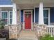 Close-up of the home's entry featuring a red front door, stone accents, and a covered porch with white pillars at 1946 Jeffery Nw Rd, Atlanta, GA 30318