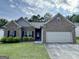 Charming single-story brick home with a well-manicured lawn, an attached two-car garage and welcoming curb appeal at 6703 Biscayne Blvd, Rex, GA 30273