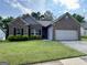 Charming brick home with manicured lawn, black shutters, and a two-car garage at 6703 Biscayne Blvd, Rex, GA 30273