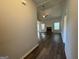 Hallway with hardwood floors leading to a well-lit living area with fireplace and ample natural light at 6703 Biscayne Blvd, Rex, GA 30273