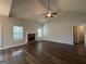 Inviting living room featuring a cozy brick fireplace, vaulted ceilings with fan, and beautiful hardwood flooring at 6703 Biscayne Blvd, Rex, GA 30273