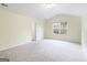 Spacious bedroom with neutral carpet, window, and a door at 1562 Onalee Dr, Hampton, GA 30228