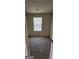 Neutral-toned carpeted bedroom with a single window, featuring a small closet with rack and shelf at 1562 Onalee Dr, Hampton, GA 30228