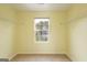 Bright empty bedroom features a window overlooking the neighborhood, neutral walls, and closet storage at 1562 Onalee Dr, Hampton, GA 30228