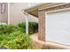 Exterior side view leading to a garage entry with brick siding and well-maintained landscaping at 1562 Onalee Dr, Hampton, GA 30228