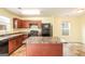 Kitchen featuring dark wooden cabinetry, a central island, and modern appliances at 1562 Onalee Dr, Hampton, GA 30228