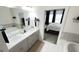 Bathroom featuring dual sinks, a soaking tub, and a bedroom doorway for added convenience at 2282 Mclean Chase Se, Smyrna, GA 30080
