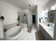 Bright bathroom with a soaking tub, glass shower, double vanity, and marble tiling throughout at 2282 Mclean Chase Se, Smyrna, GA 30080