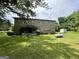 View of the back of the stone house with a propane tank and shed in the large yard at 1085 Pleasant Hill Nw Rd, Conyers, GA 30012