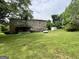 Spacious backyard with lush grass, a storage shed, and the back of the stone house at 1085 Pleasant Hill Nw Rd, Conyers, GA 30012