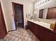 A functional bathroom with a tiled floor, dark wood vanity and framed mirror with vintage lighting at 1085 Pleasant Hill Nw Rd, Conyers, GA 30012