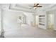 Large bedroom with tray ceilings, built in shelves, neutral paint and carpet at 765 Brooks Cir, Stone Mountain, GA 30087
