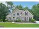 Stunning brick home featuring arched windows, a manicured lawn, and mature trees at 765 Brooks Cir, Stone Mountain, GA 30087