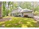Spacious backyard with a lush mossy lawn, wooden bench, and mature trees, providing shade at 335 Cedar Ln, Fayetteville, GA 30214