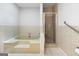 Bathroom features a soaking tub, separate shower, neutral tile, and safety grab bar at 335 Cedar Ln, Fayetteville, GA 30214