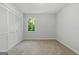Carpeted bedroom with a closet, a window providing views of trees, and neutral colored walls at 335 Cedar Ln, Fayetteville, GA 30214
