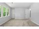 Neutral bedroom boasts two doors, a window providing views of trees, and light beige carpet flooring at 335 Cedar Ln, Fayetteville, GA 30214