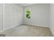 Neutral bedroom with a closet, a window providing views of trees, and light beige carpet flooring at 335 Cedar Ln, Fayetteville, GA 30214