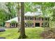 Two-story brick home with black shutters and manicured front lawn, surrounded by lush trees at 335 Cedar Ln, Fayetteville, GA 30214