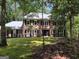Two-story brick home nestled in a wooded area with mature landscaping offering curb appeal at 335 Cedar Ln, Fayetteville, GA 30214