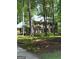 Traditional brick home nestled among mature trees offering shade and privacy, perfect for serene living at 335 Cedar Ln, Fayetteville, GA 30214