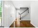 Hallway with hardwood floors, white trim, and staircase with black accents at 335 Cedar Ln, Fayetteville, GA 30214