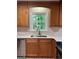 The kitchen has wood cabinets, a stainless steel dishwasher, and a view of the tree-filled backyard at 335 Cedar Ln, Fayetteville, GA 30214