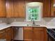 This kitchen has wood cabinets, stainless steel appliances, and a view of the tree-filled backyard at 335 Cedar Ln, Fayetteville, GA 30214