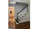 Staircase with sleek black and white trim and wooden flooring on main level at 335 Cedar Ln, Fayetteville, GA 30214