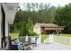 Exterior shot from a deck overlooking a large yard and outbuilding with covered bay and a wooded area at 124 Wynn Rd, Mcdonough, GA 30252
