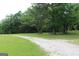 Gravel driveway surrounded by mature trees and lush greenery leading to a secluded property at 124 Wynn Rd, Mcdonough, GA 30252