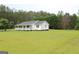 Spacious white home features a lovely covered porch, nestled in a green yard at 124 Wynn Rd, Mcdonough, GA 30252