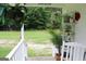 Covered porch area features white railings, greenery, and decorative items at 124 Wynn Rd, Mcdonough, GA 30252
