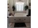 Large white tile bathroom with a decorative garden, a soaking tub and shutters on the window at 531 Grant Rd, Brooks, GA 30205