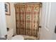 Functional bathroom with a toilet, patterned shower curtain, and classic decor at 531 Grant Rd, Brooks, GA 30205