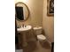 Elegant powder room with pedestal sink, tiled floors, and decorative mirror at 531 Grant Rd, Brooks, GA 30205