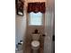 Cozy powder room with a classic toilet, window, and simple decor at 531 Grant Rd, Brooks, GA 30205