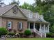 Charming home featuring a stone facade, inviting front porch, dormer windows, and lush landscaping at 531 Grant Rd, Brooks, GA 30205